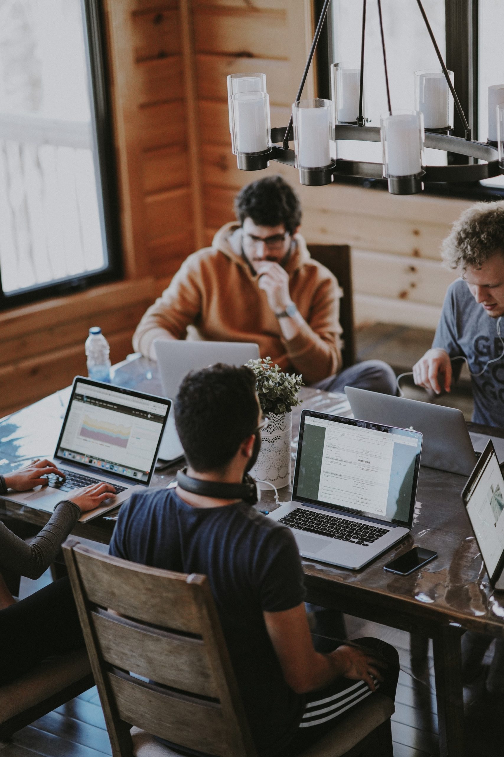 Pessoas reunidas na mesa com notebooks